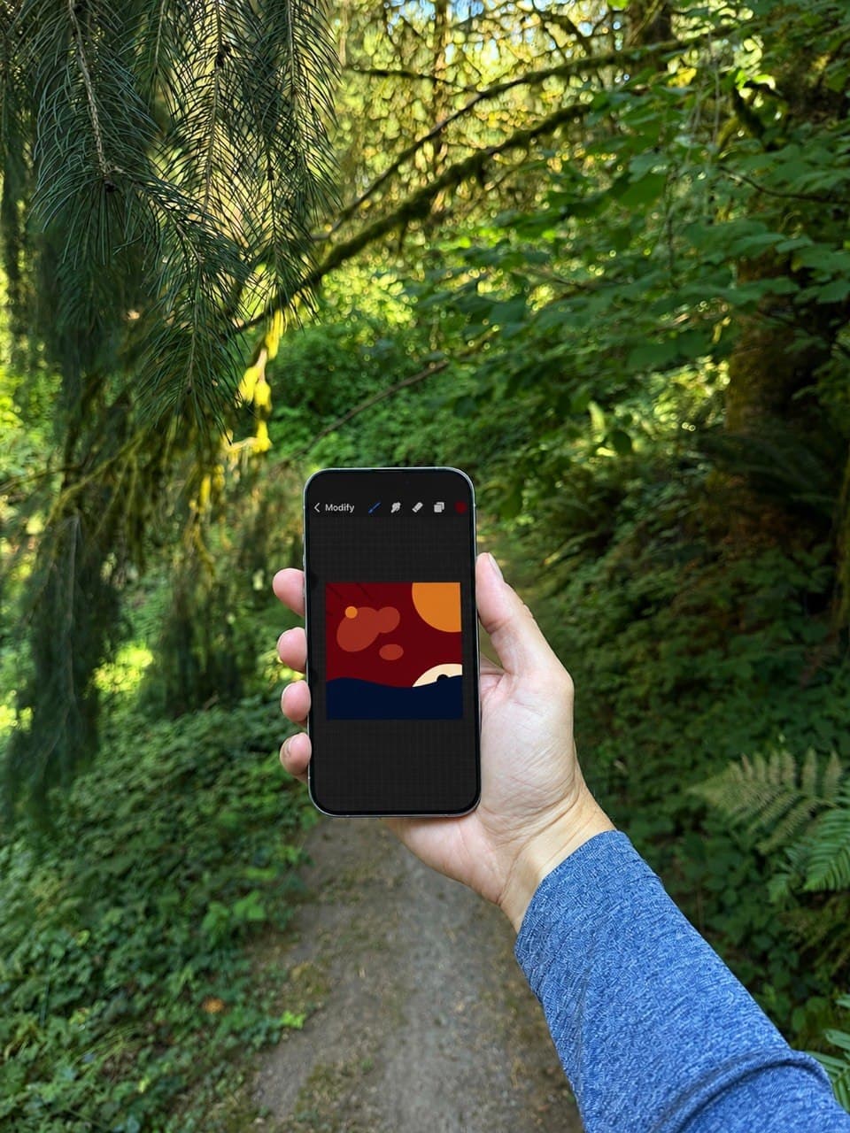 Thomas Goetz holding a phone displaying Portland Sun on a wooded path
