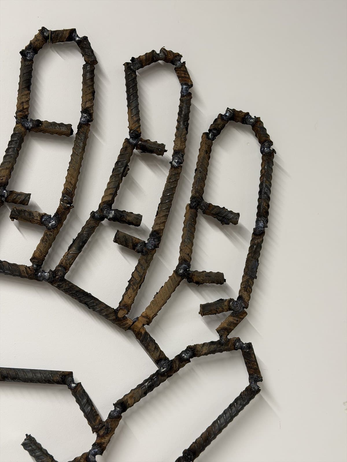 Close view of welded rebar fingers and the outline of a palm