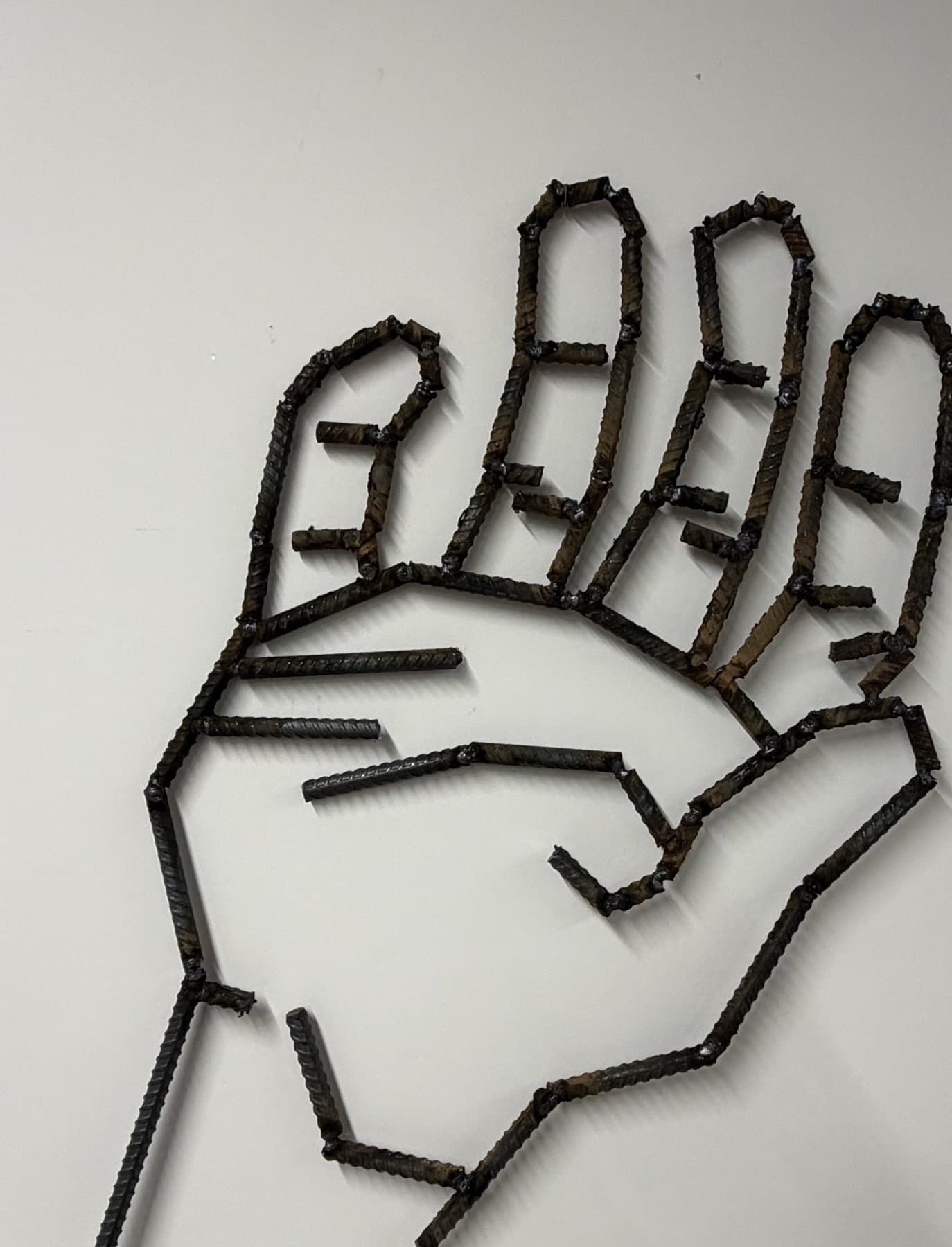 Wall-mounted open hand constructed from welded rebar