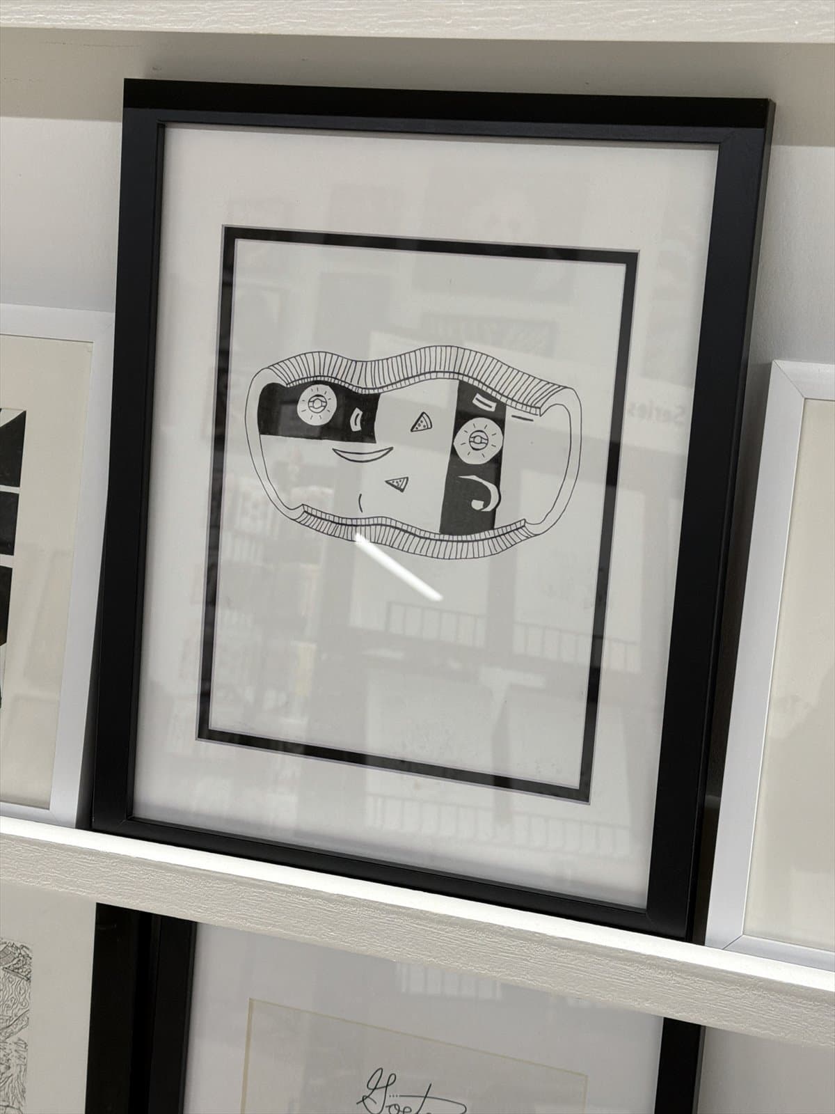 Smiling Shell, an ink drawing presented in a black frame
